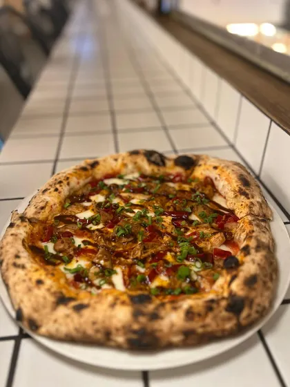 A side view of our Adobo Chicken pizza, sitting pretty on the counter. Look at that perfectly charred crust.