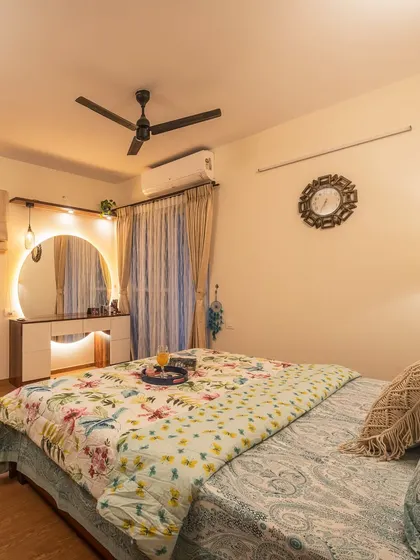 A cozy bedroom corner highlighting the vanity unit with an illuminated mirror. The warm lighting and soft textiles create a perfect spot for getting ready.