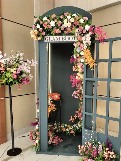 A closer look at the floral arrangement on the "Glam Booth." The mix of pink, white, and orange flowers cascades down the side, making it an elegant and whimsical prop for any event.