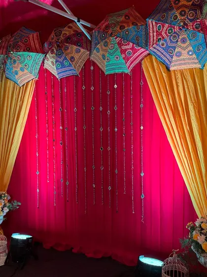 A close-up of the colorful Rajasthani umbrellas and hangings used for a Mehendi or Haldi backdrop.