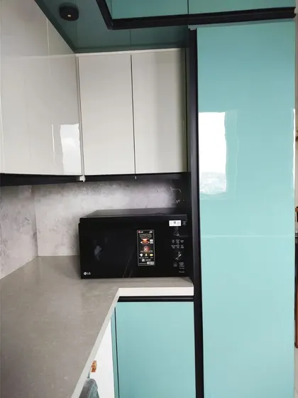 A dedicated appliance garage with a microwave oven neatly tucked away. The tall cabinet next to it provides additional storage, keeping the countertop free of clutter.