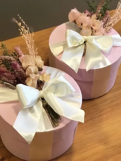 An example of our custom packaging for bridesmaid hampers. These beautiful pink hat boxes are adorned with dried florals and a satin ribbon, creating a truly special gift for your bride tribe.