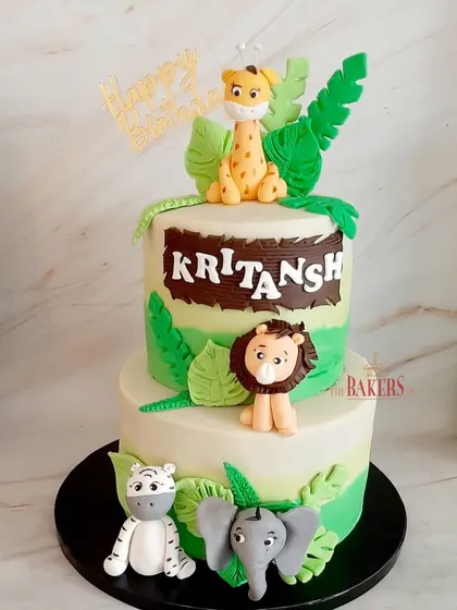 A two-tier jungle theme cake for Kritansh with his favorite animals. This minimal-fondant cake features a lion, giraffe, zebra, and elephant, perfect for a wild birthday adventure.