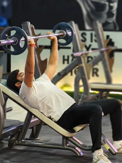 A client executes an incline barbell press. We focus on building a strong foundation in chest development through classic, effective strength training exercises.