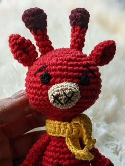 A bright red giraffe with a yellow scarf, showing how colors can be customized.