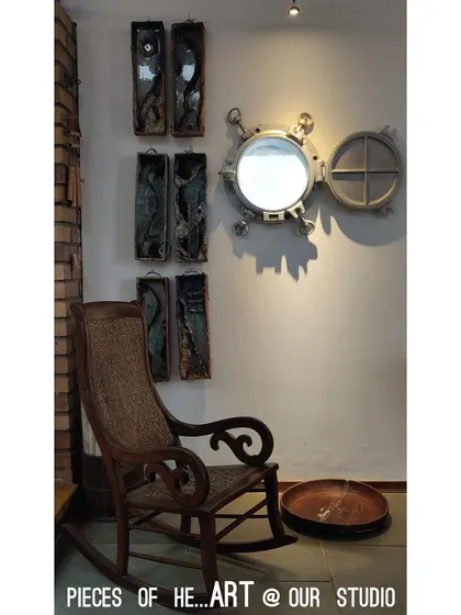 Pieces of our heart and art are found throughout our studio. A repurposed ship's porthole serves as a mirror, sharing space with a classic rocking chair and other handmade artworks that inspire us daily.