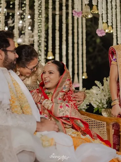A candid moment of laughter and affection between the couple and their family on the mandap.