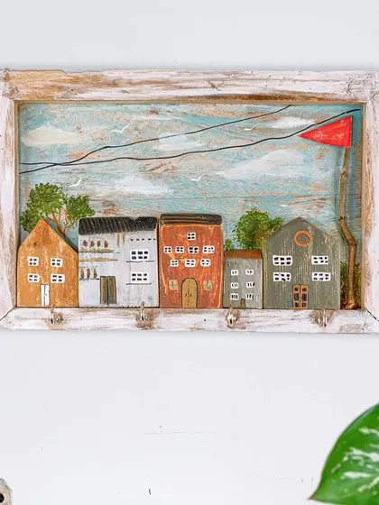 A full view of the miniature house keyholder hanging on a wall. It's a charming and practical piece of art that brings a little bit of storybook magic into the home.