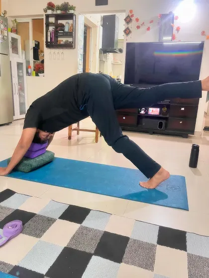 A client practices a three-legged downward dog, a pose that builds upper body strength while stretching the hamstrings and opening the hips.