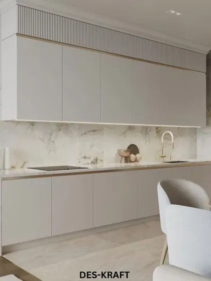 This kitchen features sleek, handleless cabinets with a fluted texture on the upper portion, paired with a stunning gold-veined marble backsplash for a touch of luxury.