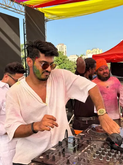 A side angle of me working the decks at the Holi party. Even with all the chaos and color, the focus is on delivering a flawless music experience.