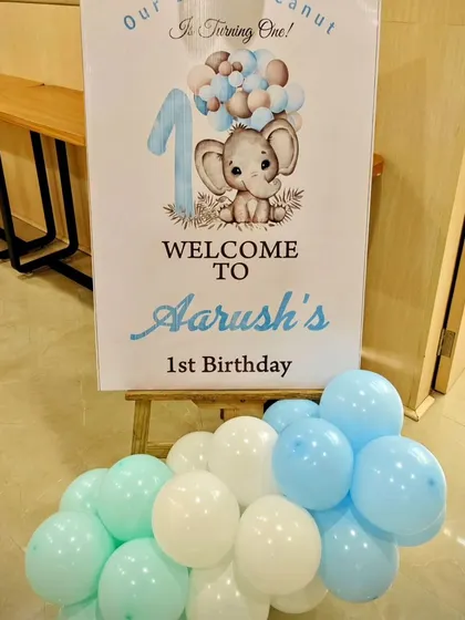A personalized welcome sign for Aarush's elephant-themed first birthday, complete with a matching balloon cluster.