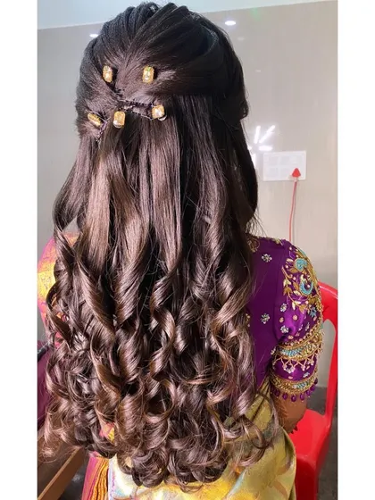 This reception hairstyle features a twisted half-updo with tight, bouncy curls. I used small golden beads along the twist to add a subtle decorative element that matches the client's jewellery.