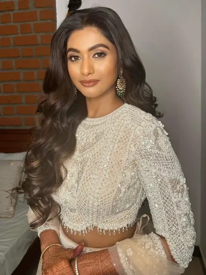 A glamorous reception look in a stunning white and silver ensemble. The makeup features a soft smokey eye and a nude lip.