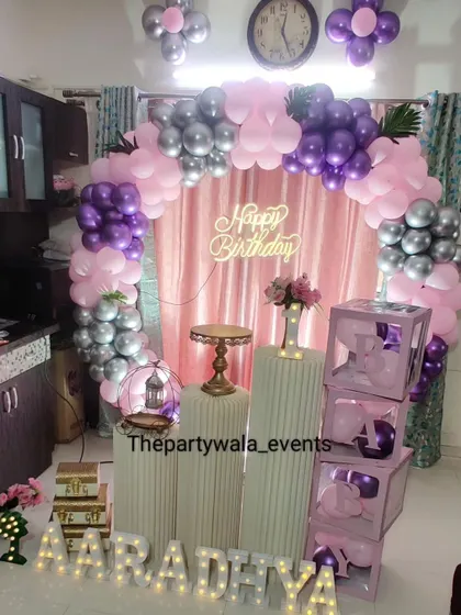 A home-based ring decoration with purple, pink, and silver balloons.