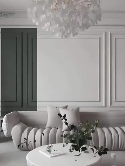 A concept image showing a living room with classic wall molding and a modern, curved sofa. The contrast between the dark green panel and the white walls adds a dramatic flair.