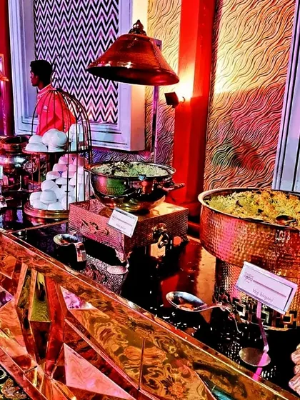 The food display is an art form in itself. Here, a vibrant and stylish buffet setup with copper and gold serveware adds a touch of glamour and makes the culinary journey a feast for the eyes as well.
