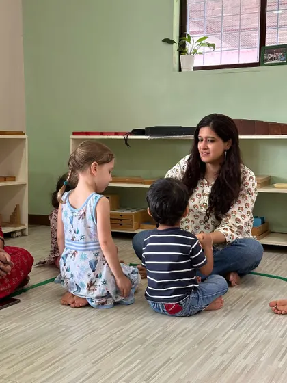 A teacher engages with two young students, creating a warm and personal learning environment where every child feels seen and encouraged.
