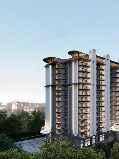 This perspective shows the apartment building set against the city skyline. The vertical fins and rhythmic balconies give the facade a sense of order and depth, creating a strong visual presence.