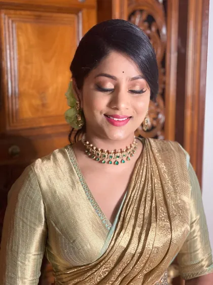 A beautiful, soft glam look on this client. The golden-green saree is complemented by shimmery eyeshadow and a bright pink lip.