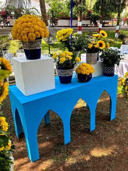 The arched blue console table, styled with a variety of floral arrangements in patterned pots, creating a beautiful focal point.