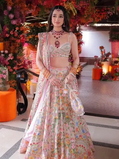 The full Abu Jani Sandeep Khosla lehenga, a masterpiece of color and embroidery. The makeup is kept soft and romantic to complement the outfit.