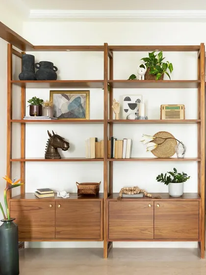 This open bookshelf and storage unit is crafted from warm teak wood. The clean lines and ample shelving make it a perfect piece for displaying books, decor, and cherished belongings.