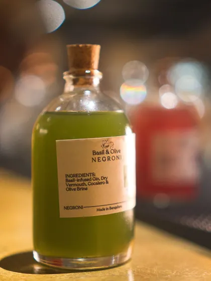 The Basil & Olive Negroni, a bright green, savory cocktail from our Negroni Week menu. This drink demonstrates our ability to deconstruct and reinvent classics with fresh, unexpected ingredients.