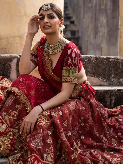 A regal pose in our classic red bridal lehenga. This is a timeless piece that will make you feel like a queen on your wedding day.