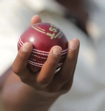 A close-up of a bowler's grip on the cricket ball, a small but critical detail that we focus on perfecting.