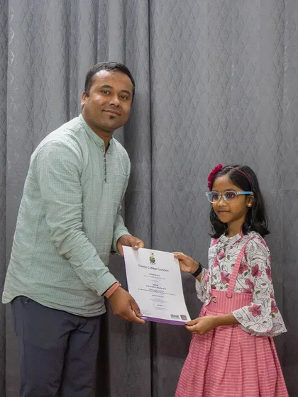 A young student receives her certificate from Trinity College London. I provide specialized coaching to meet the requirements of different exam boards.