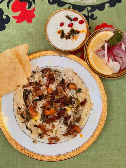 Another look at our Malabar Buff Biryani, served with cooling raita and a fresh salad. The fragrant rice and tender meat make this a classic and unapologetically Mappila dish.