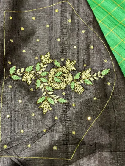 The embroidered blouse piece that comes with our green Tussar saree. The intricate floral design on the back adds a custom designer touch to your look.