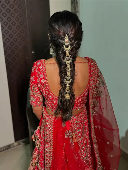 A detailed look at the traditional bridal braid, adorned with beautiful chandbali-style hair accessories that run down its length.