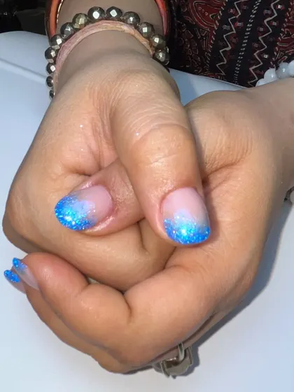 A close-up of the ocean-inspired glitter fade. The bright blue reflective glitter is packed at the tips for a sparkling, textured look.