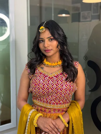 A portrait of the beautiful Haldi makeup look. The soft waves and floral jewelry complement the fresh and glowing makeup perfectly.