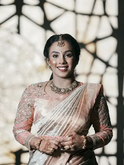 A beautiful portrait of the bride against a patterned background, which complements the intricate design of her blouse.