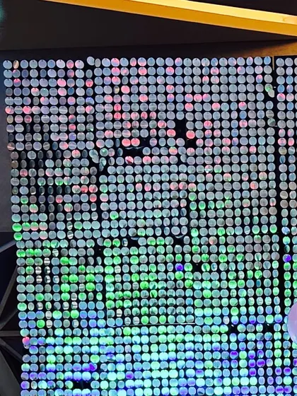 A close-up of an iridescent shimmer wall, reflecting light in multiple colors to create a dazzling effect.