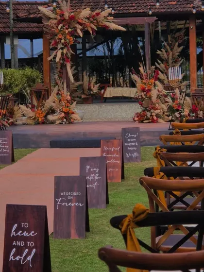 For this intimate outdoor wedding, I designed a boho-chic ceremony space using earthy florals and pampas grass. The personalized aisle signs, with quotes chosen by the couple, added a narrative touch that made the walk to the mandap deeply personal.