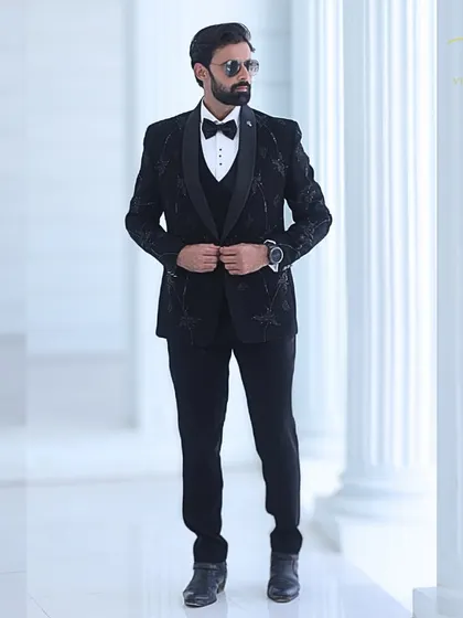 A full view of the custom black tuxedo, showing the balance between the detailed embroidery and the clean, tailored lines of the suit.