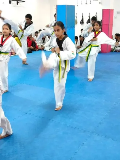 A dynamic shot of students executing kicks in unison.