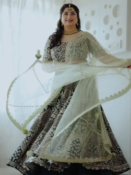 A bride twirls in her heavily embroidered lehenga, showing off the beautiful movement and detail of her outfit.