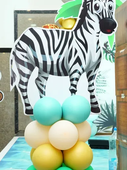 A close-up of a zebra cutout on a balloon pillar, part of the detailed decor for a safari-themed event.