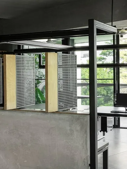 The main studio floor at 'Project 113' features custom-designed workstations and partitions made of perforated steel and birch ply. These elements divide the space lightly, maintaining an open, collaborative atmosphere while providing a degree of personal space.
