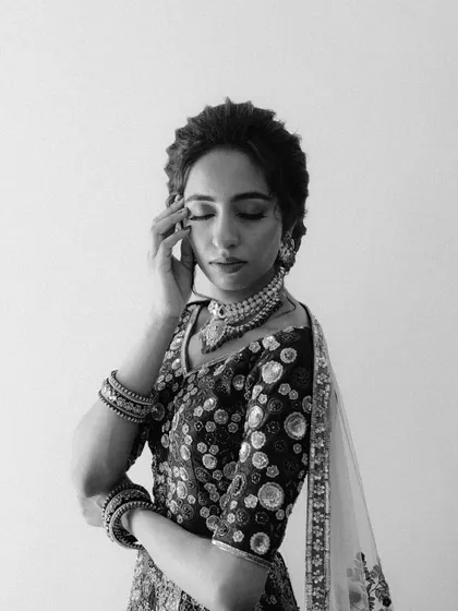A serene, black and white portrait of a bride with her eyes closed. The image captures a moment of quiet reflection and inner peace amidst the excitement of the day.
