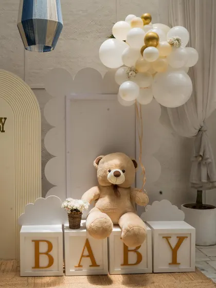 A detail shot from the luxury teddy bear baby shower, showing a plush teddy holding a balloon bouquet next to the "BABY" blocks. It’s these sweet details that make the theme special.