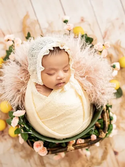 Such a vintage beauty, all tucked in with a delicate bonnet and surrounded by soft florals. I carefully style each shot to create a unique and artistic newborn portrait.