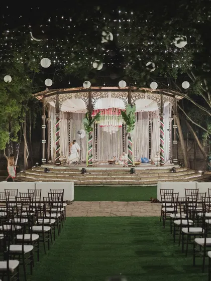 The wedding stage at night, illuminated by hanging lanterns and spotlights, creating a magical ambiance.