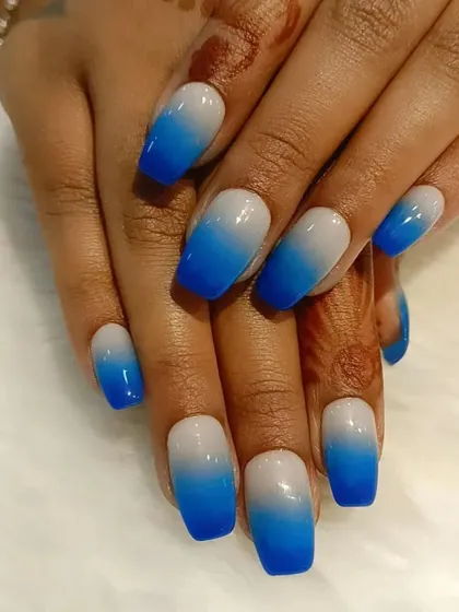 A bold blue ombre on square-shaped nails, fading from a neutral base to a vibrant royal blue.