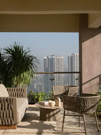 A simple, elegant balcony in our Soft Serve project, with woven outdoor furniture that offers a comfortable spot to enjoy the city views.